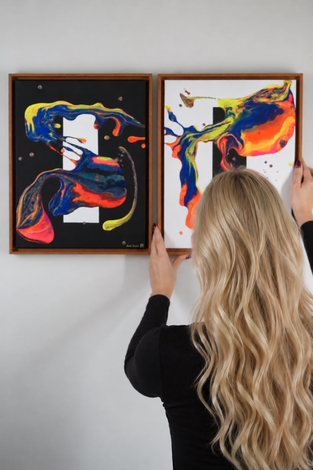 Nágila Aguiar pendurando obras no ateliê
